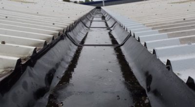 Image showing cut edge corrosion on metal roof sheeting and corrosion being fixed on the right hand side